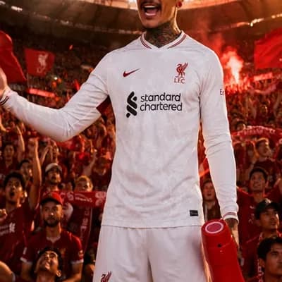 AI generated video: Use the reference image as the main character.

A passionate Liverpool supporter stands on the stadi...