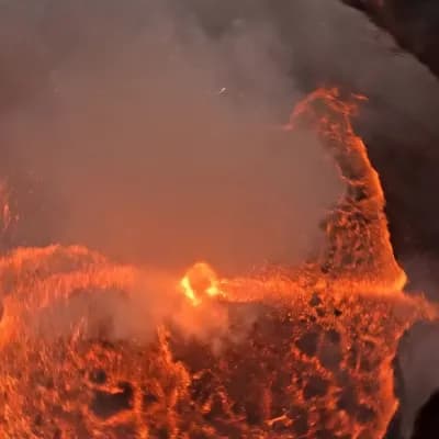 AI generated video: Camera slashes across the fractured rim of a volcano at crater height, then snap-rolls into a helica...