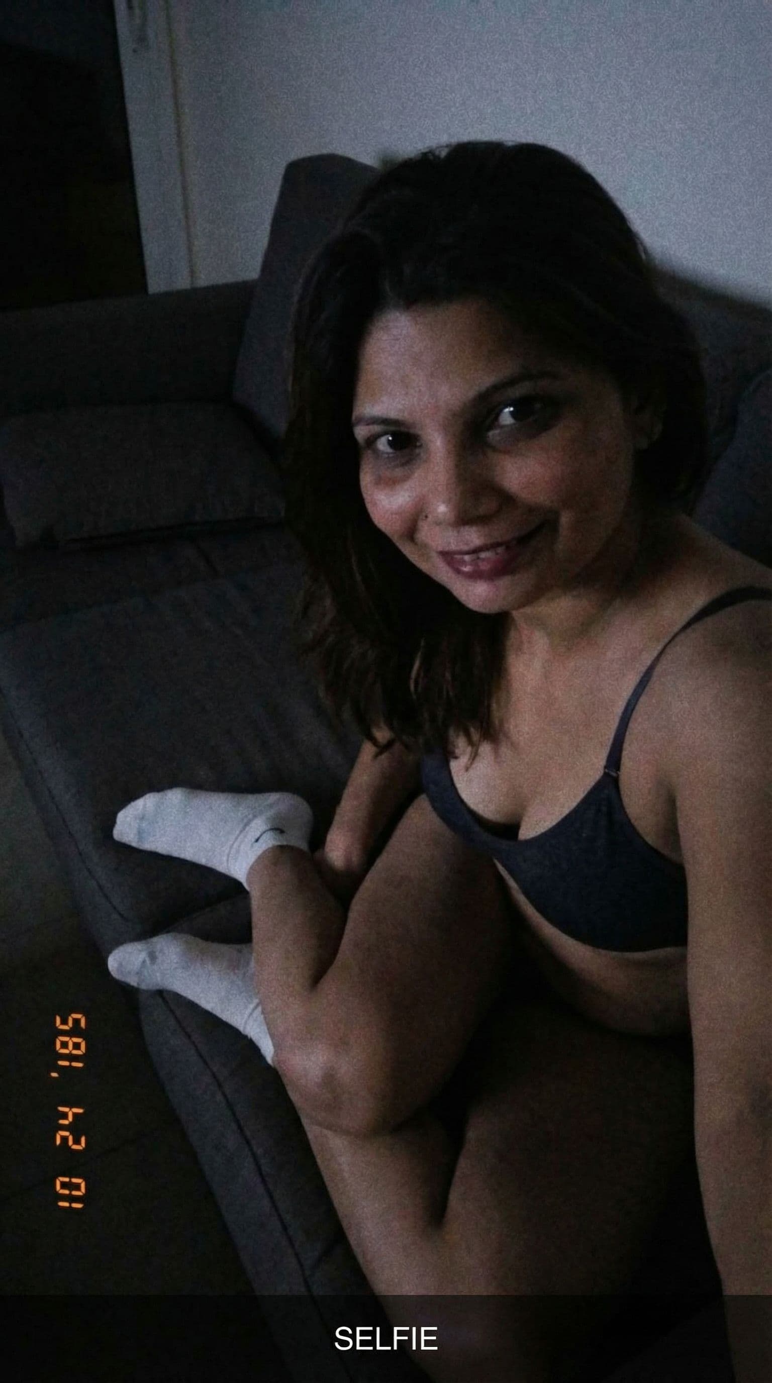 AI generated: Seductive expression, selfie looking at me,a sloppy snapshot. Sitting on a couch at night teasing(no...