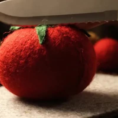 AI generated video: Slicing a felt tomato
