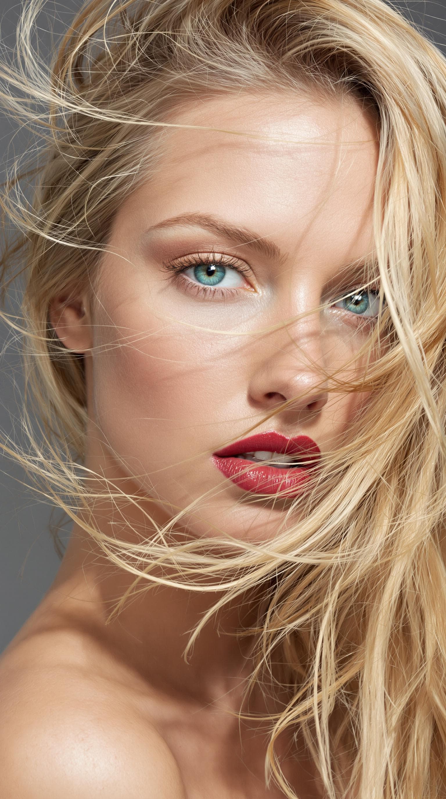 AI generated: "The image is a striking close-up portrait of a model with lustrous, tousled strawberry blonde hair ...