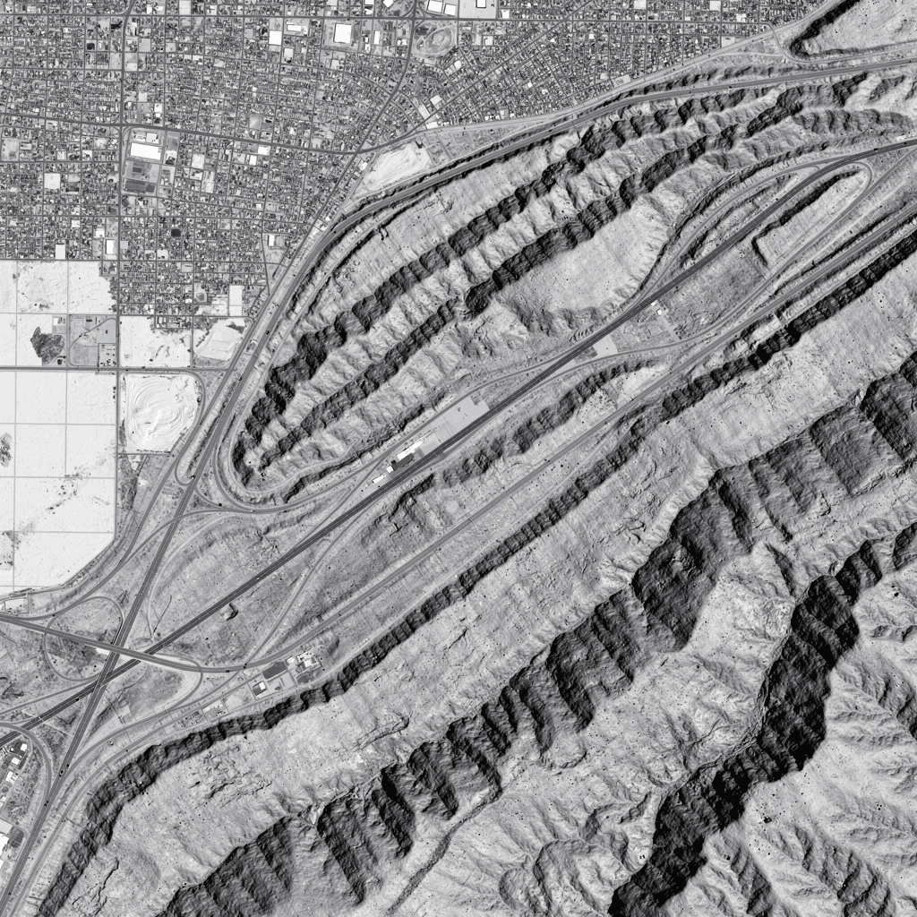 AI generated: Greyscale heightmap. Topdown 2D image. Landscape on the outskirts of a large city. Ravines and a hig...