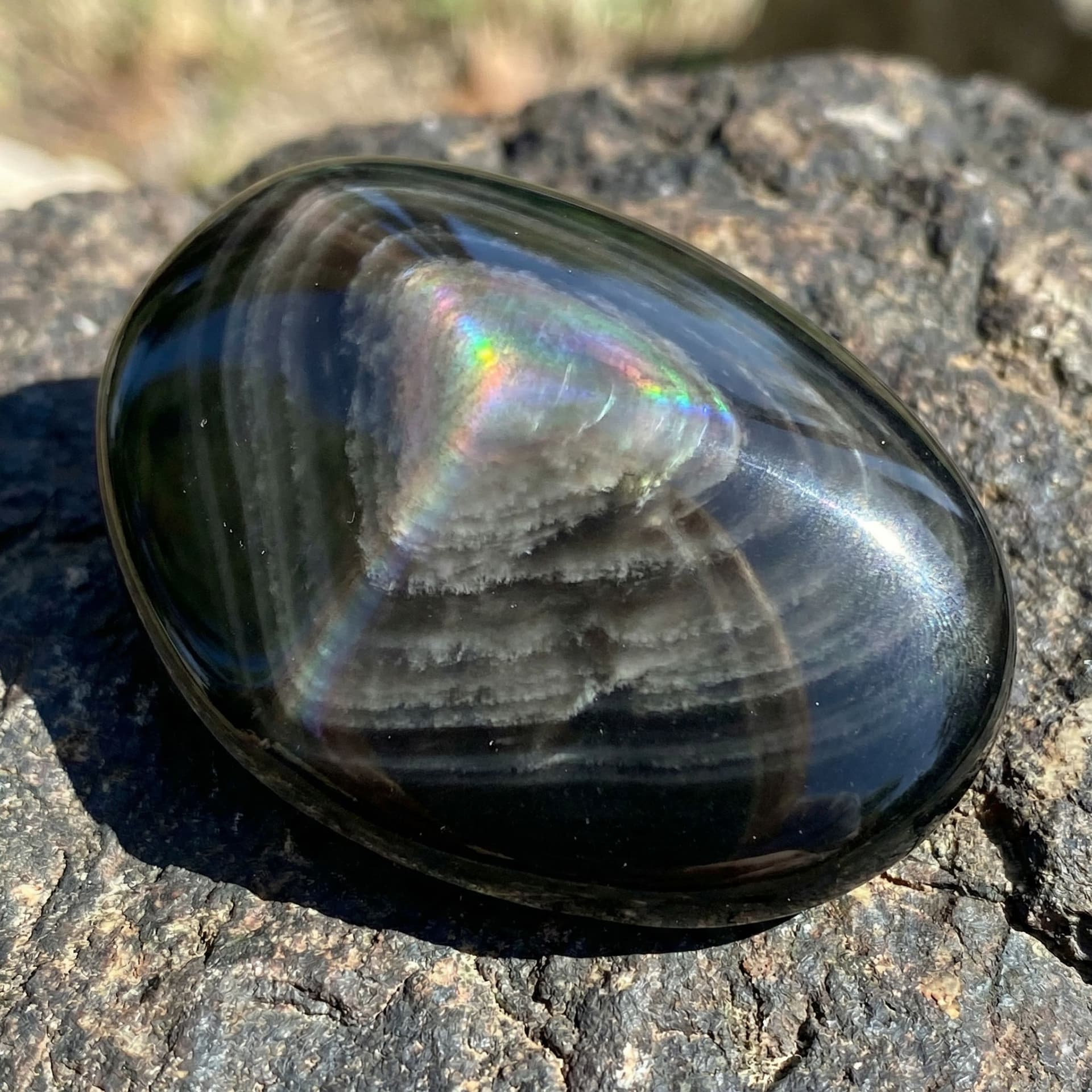 AI generated: Black obsidian with grey whisps flowing through it like clouds and it has a shine like opal