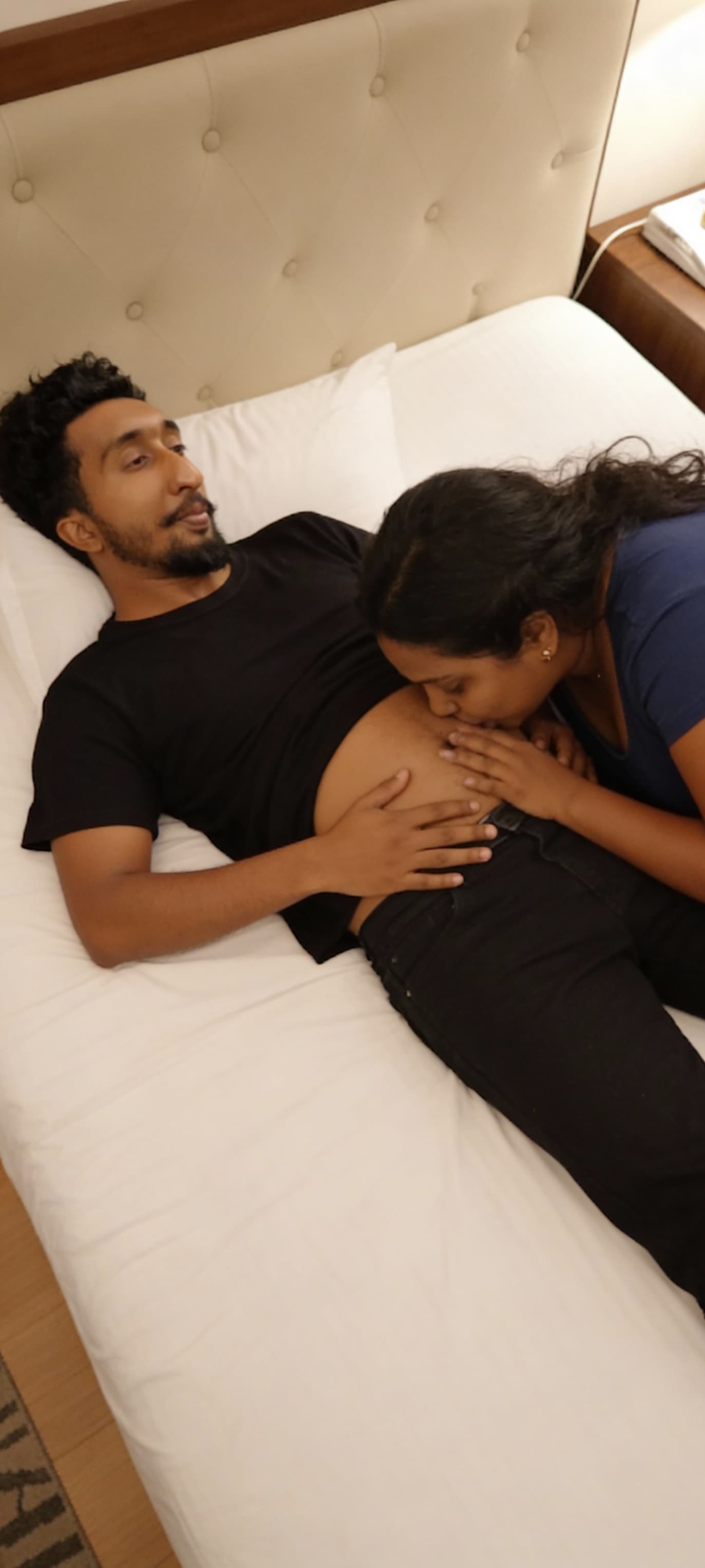 AI generated: The man and woman lying on bed with women kiss The man bellybutton 