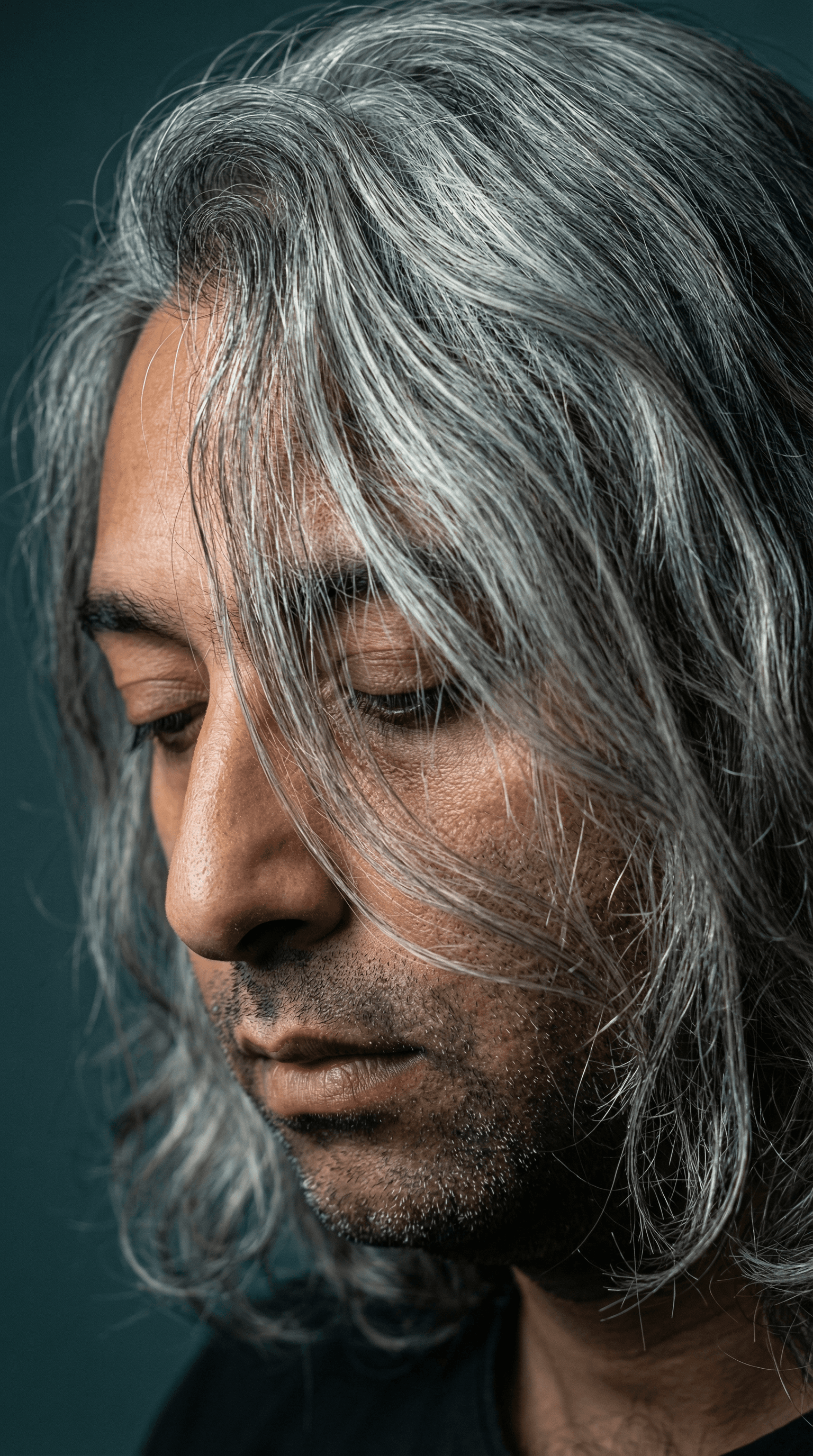 AI generated: A highly detailed, close-up portrait of a mature man with long, wavy, silver-gray hair that cascades...