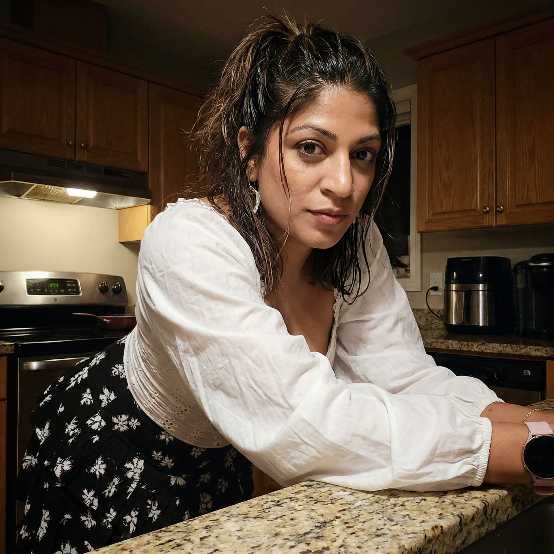 AI generated: Wearing same clothes, leans over a kitchen desk, close view, 35-year-old indian woman, busty body, a...