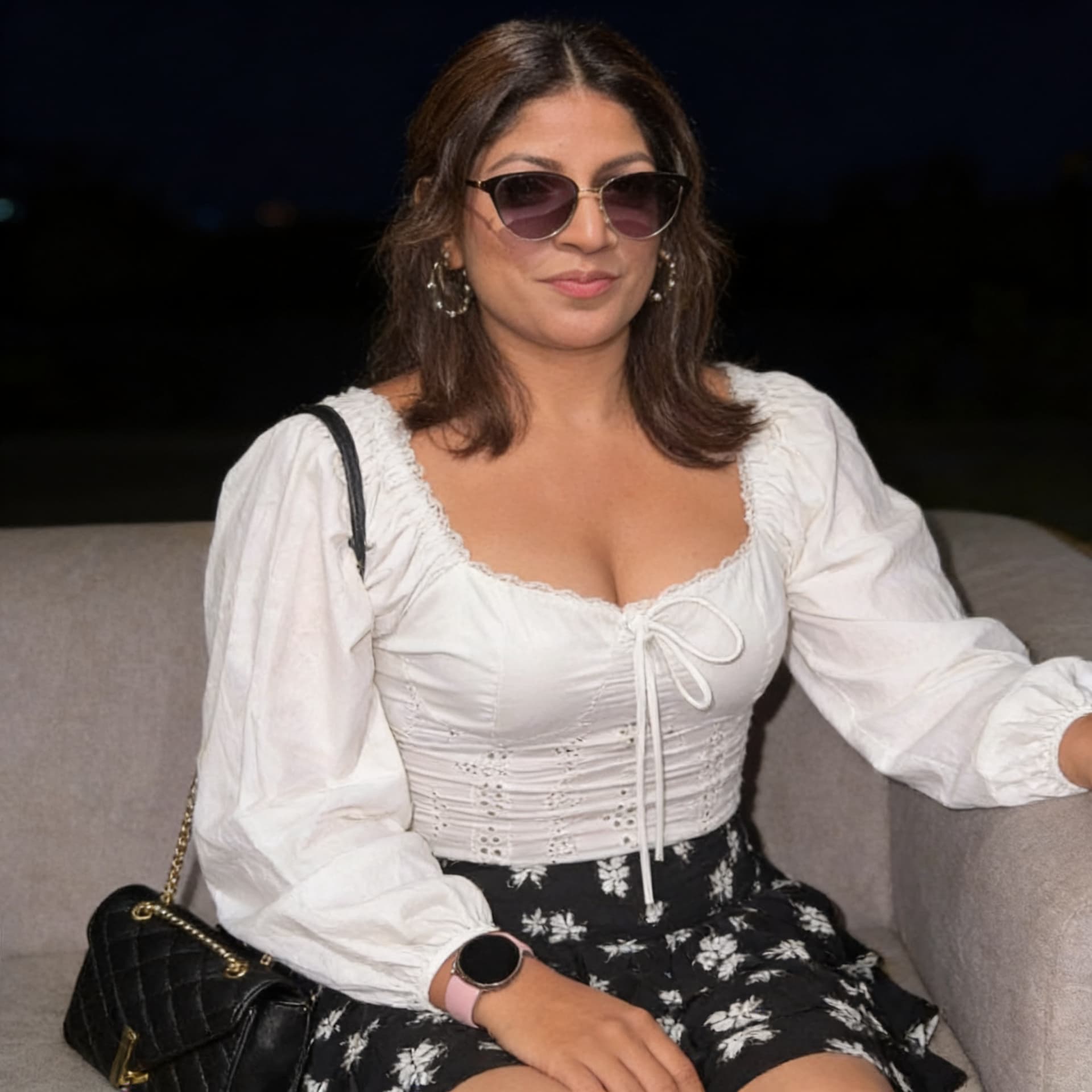 AI generated: Wearing same clothes, sitting on a couch, close view, 35-year-old indian woman, busty body, at night...