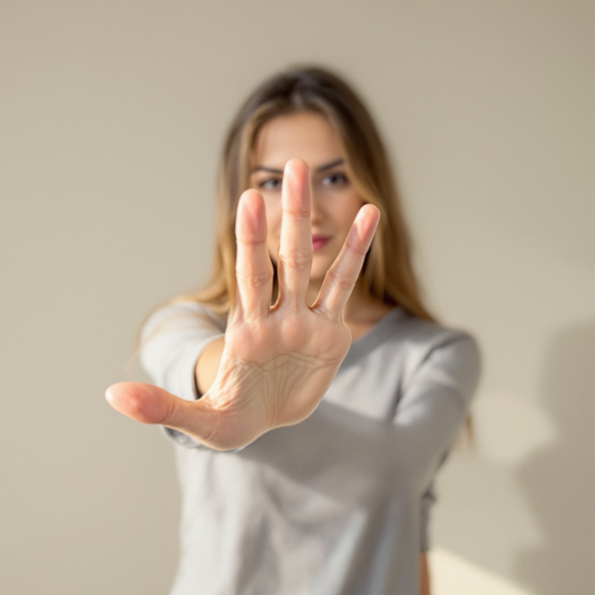 AI generated: A realistic photo of a woman standing with her hand open facing the camera, natural daylight, neutra...