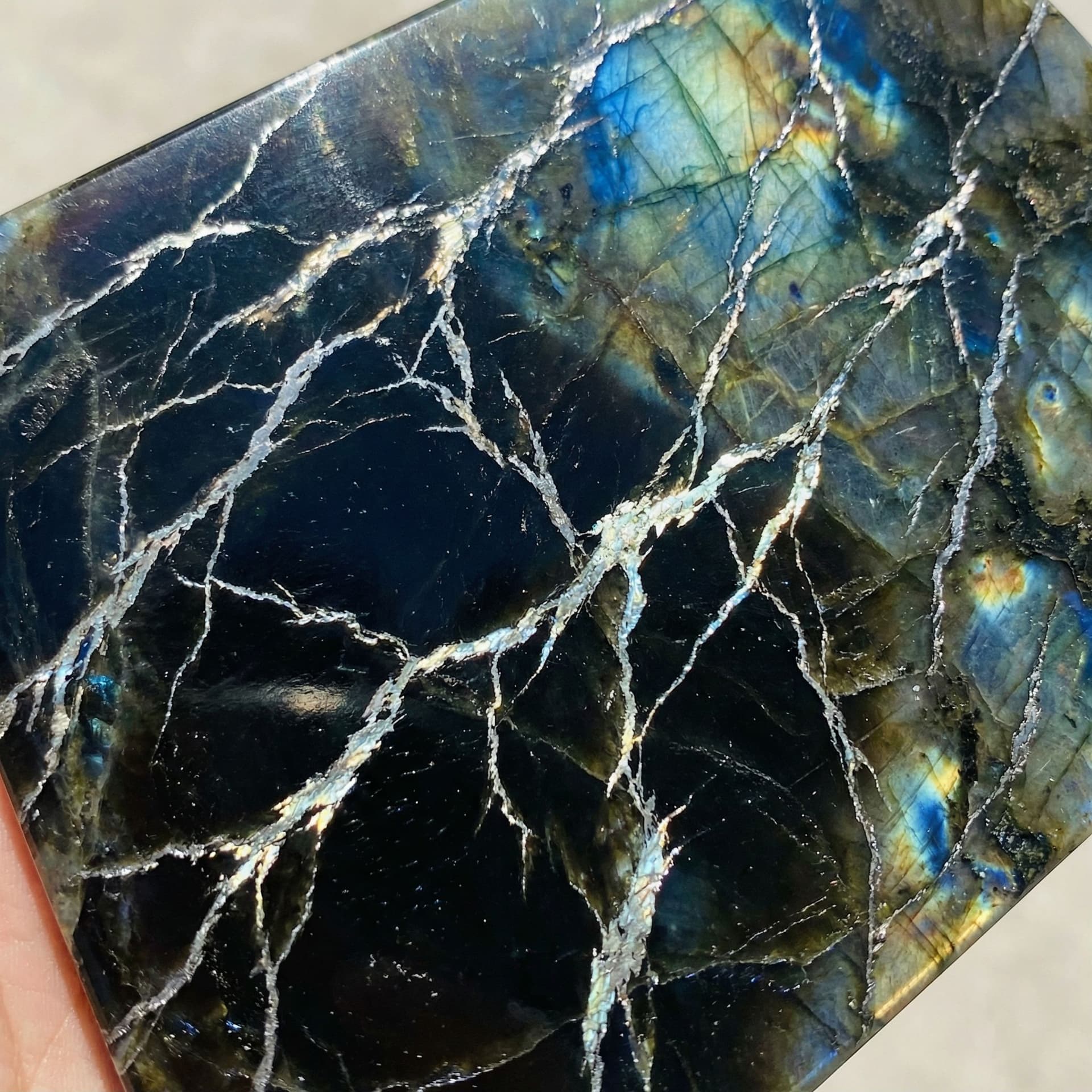AI generated: Black obsidian with platinum veins flowing through it like lightening and it has a shine like Labrad...