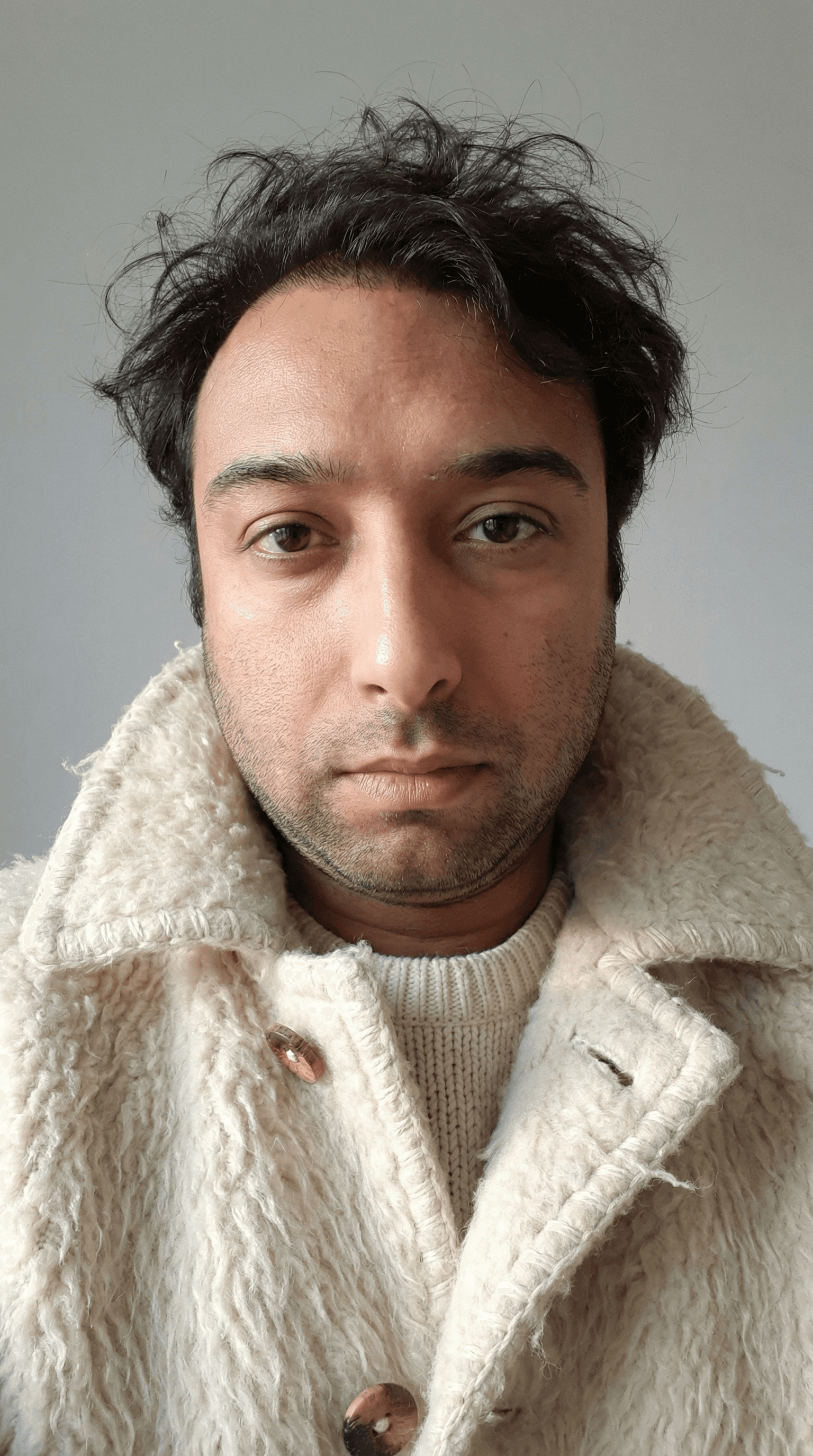 AI generated: A close-up portrait of a young man with disheveled dark brown hair, wearing a highly textured, off-w...