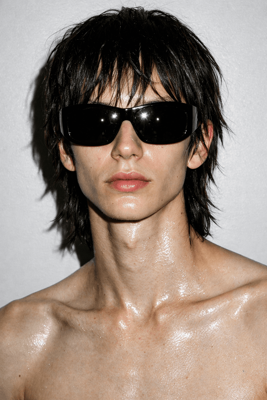 AI generated: Ultra-minimal monochrome editorial portrait of an anonymous androgynous masculine fashion model, lat...