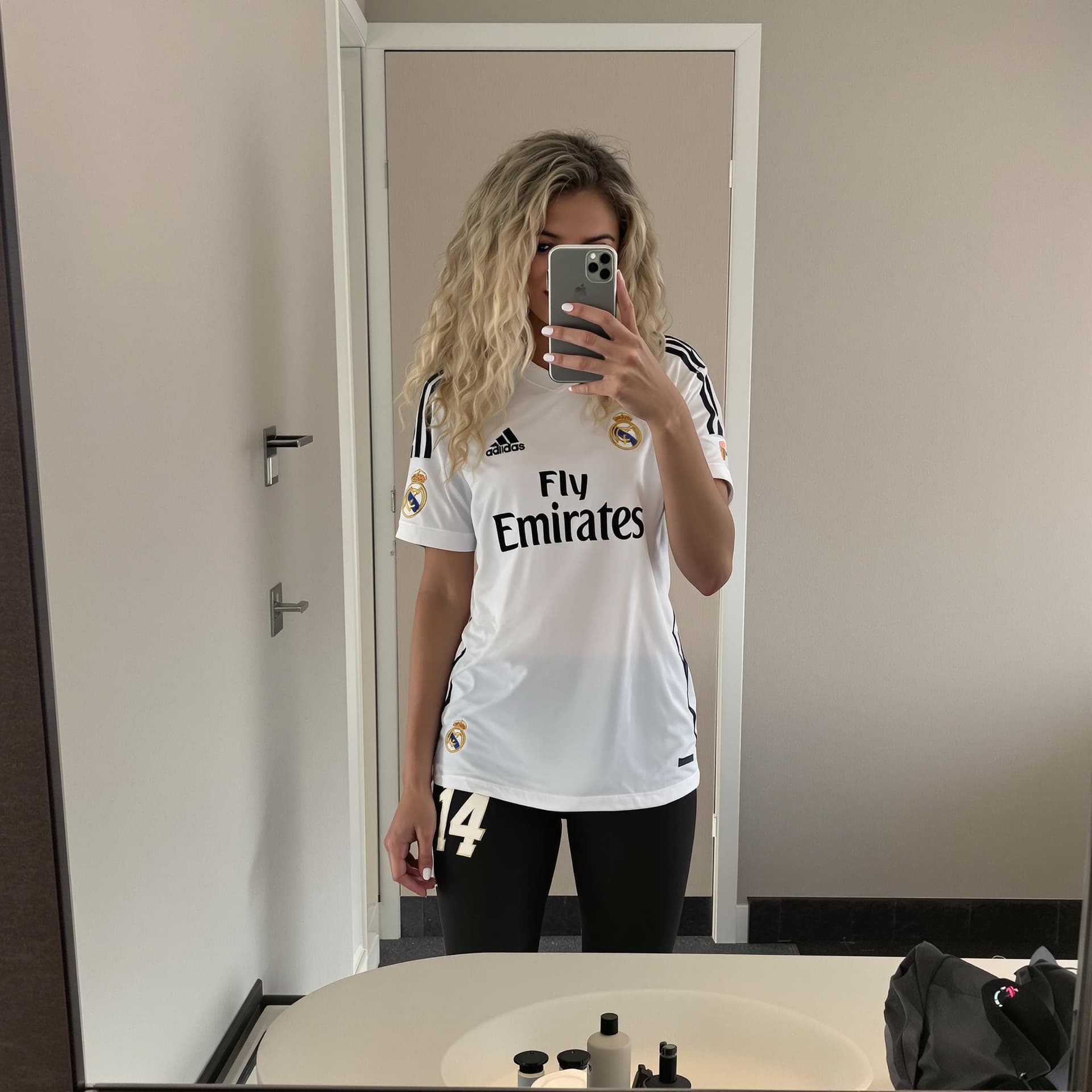AI generated: Hot italian 16-year-old girl with blonde long curly hair taking a photo at a mirror in a hotel room ...