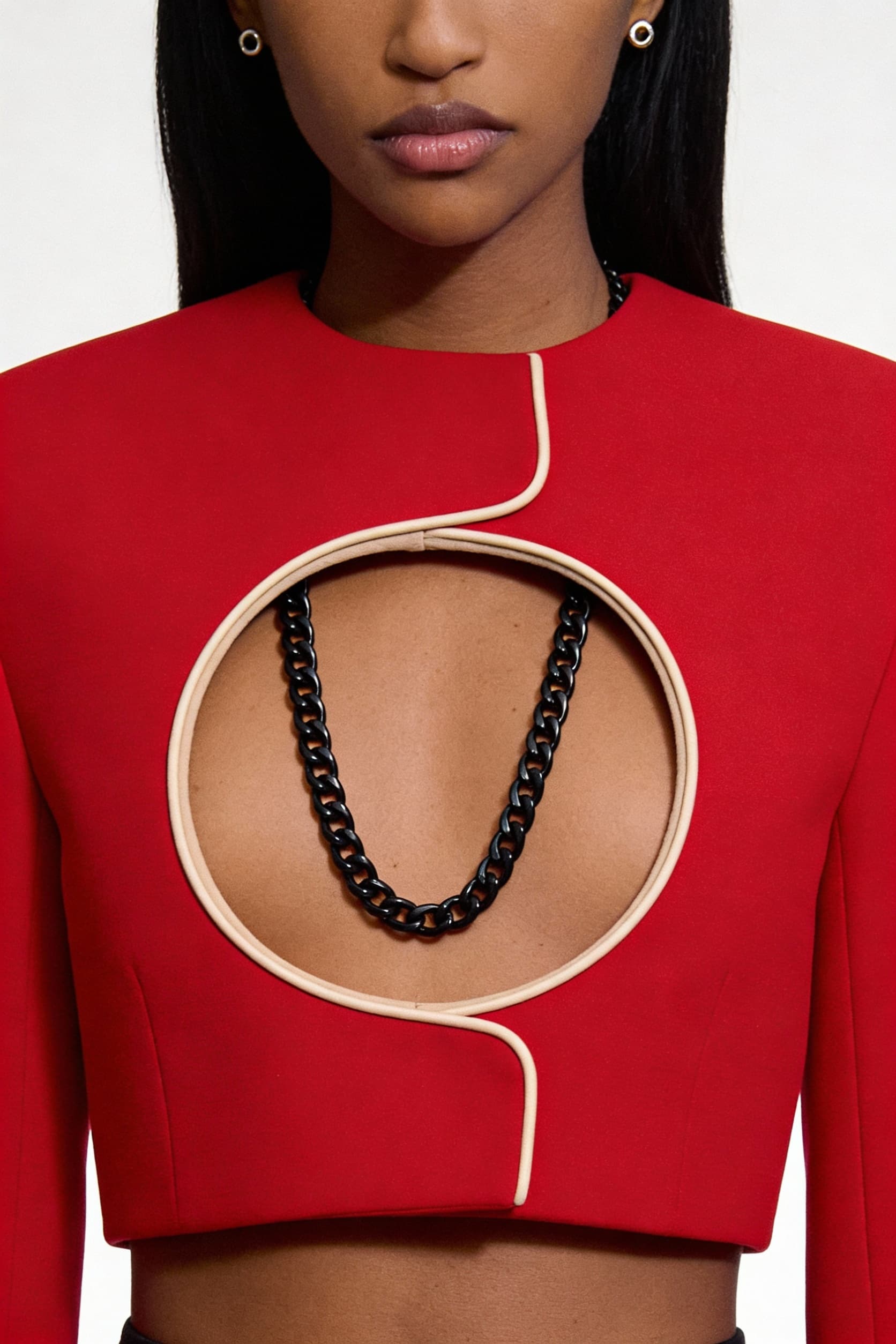 AI generated: Fashion editorial close-up. A model wears a bold, avant-garde garment: a structured red top with a l...