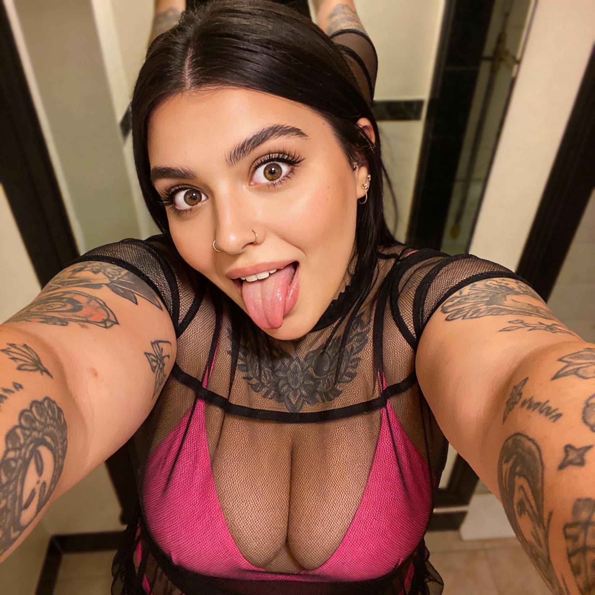 AI generated:  A woman with tattoos takes a mirror selfie wearing a black and transparent mesh dress. woman young ...