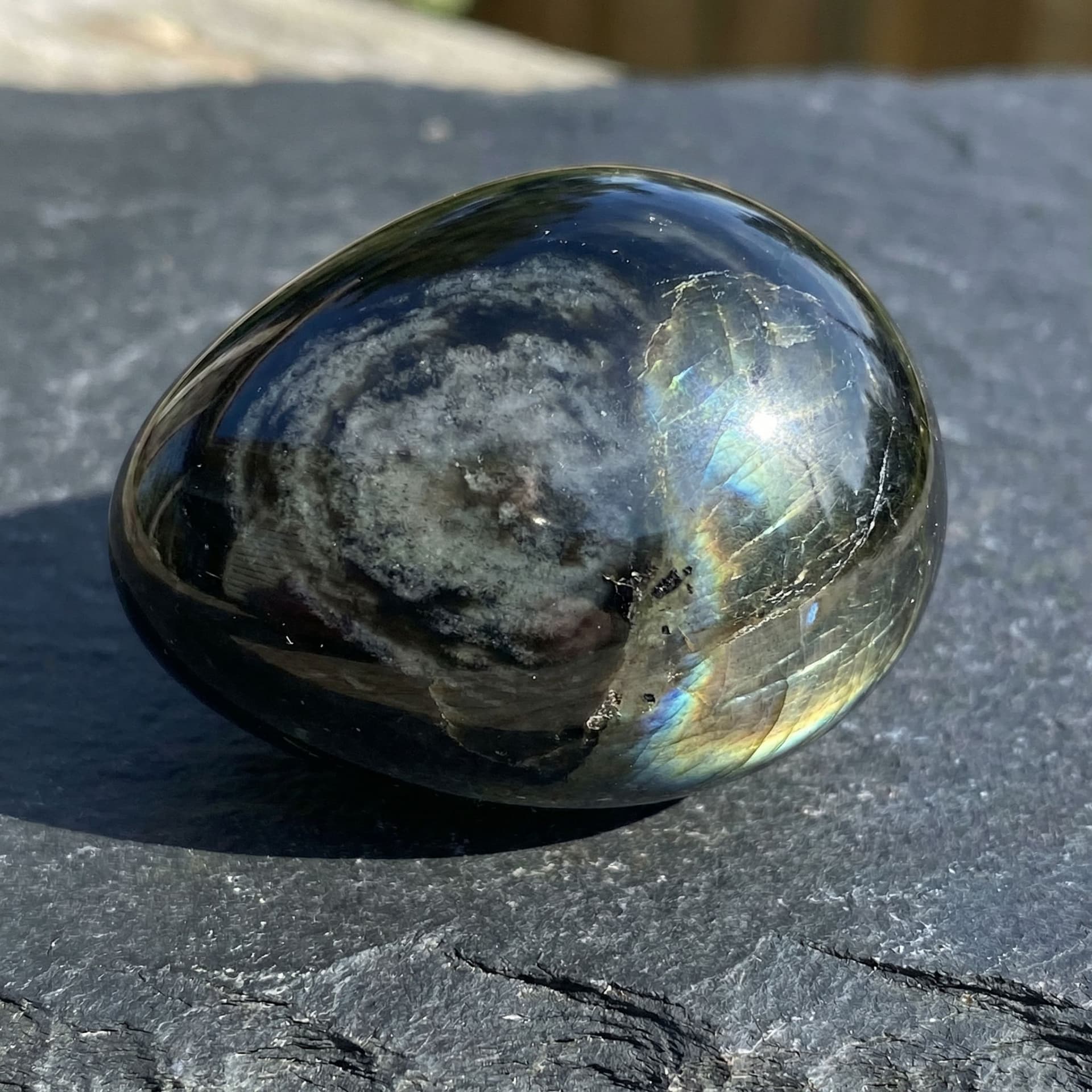 AI generated: Black obsidian with grey whips flowing through it like clouds and it has a shine like labradorite 