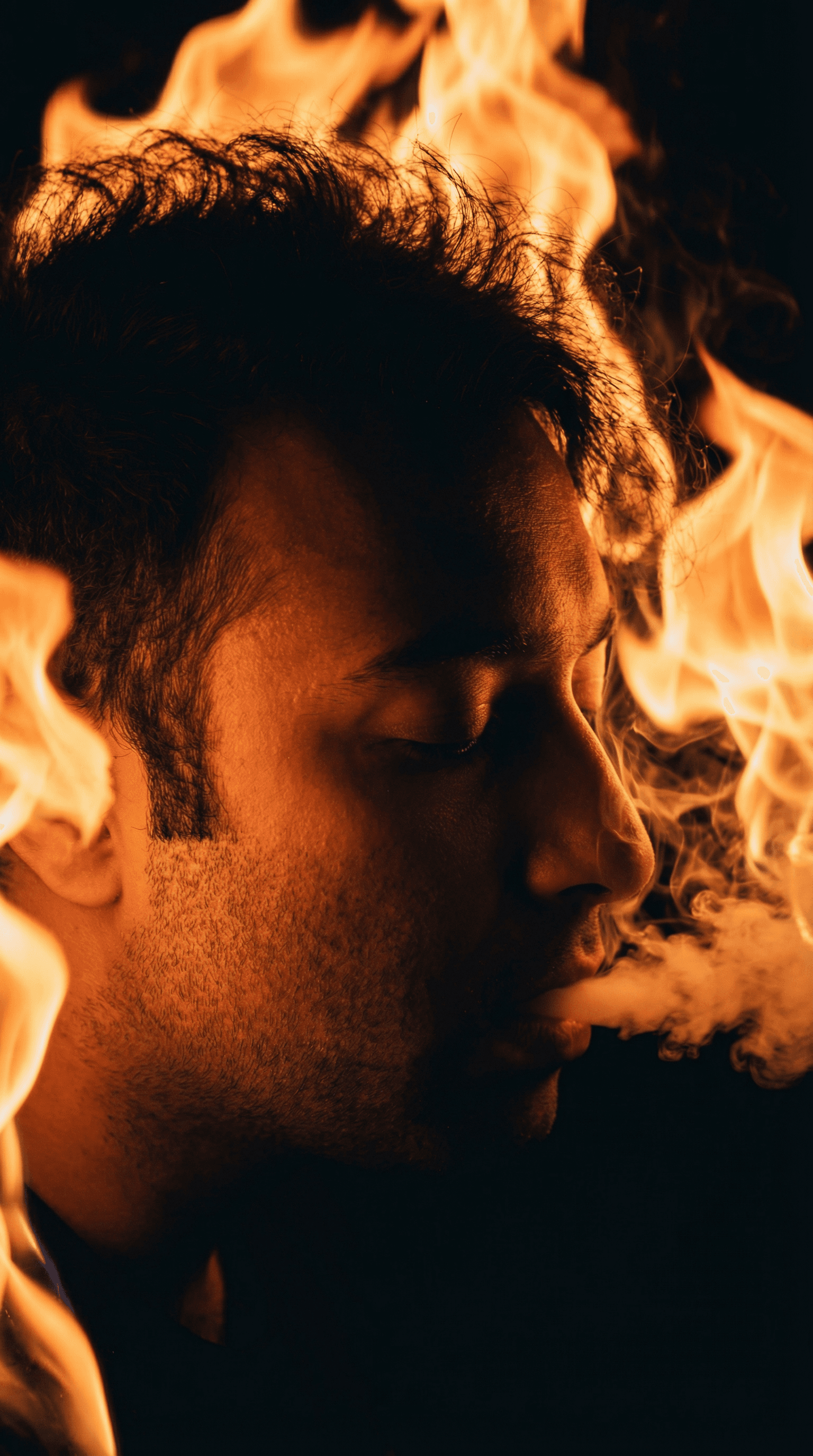 AI generated: A close-up profile of a young person with curly hair, illuminated by warm, fiery orange lighting tha...