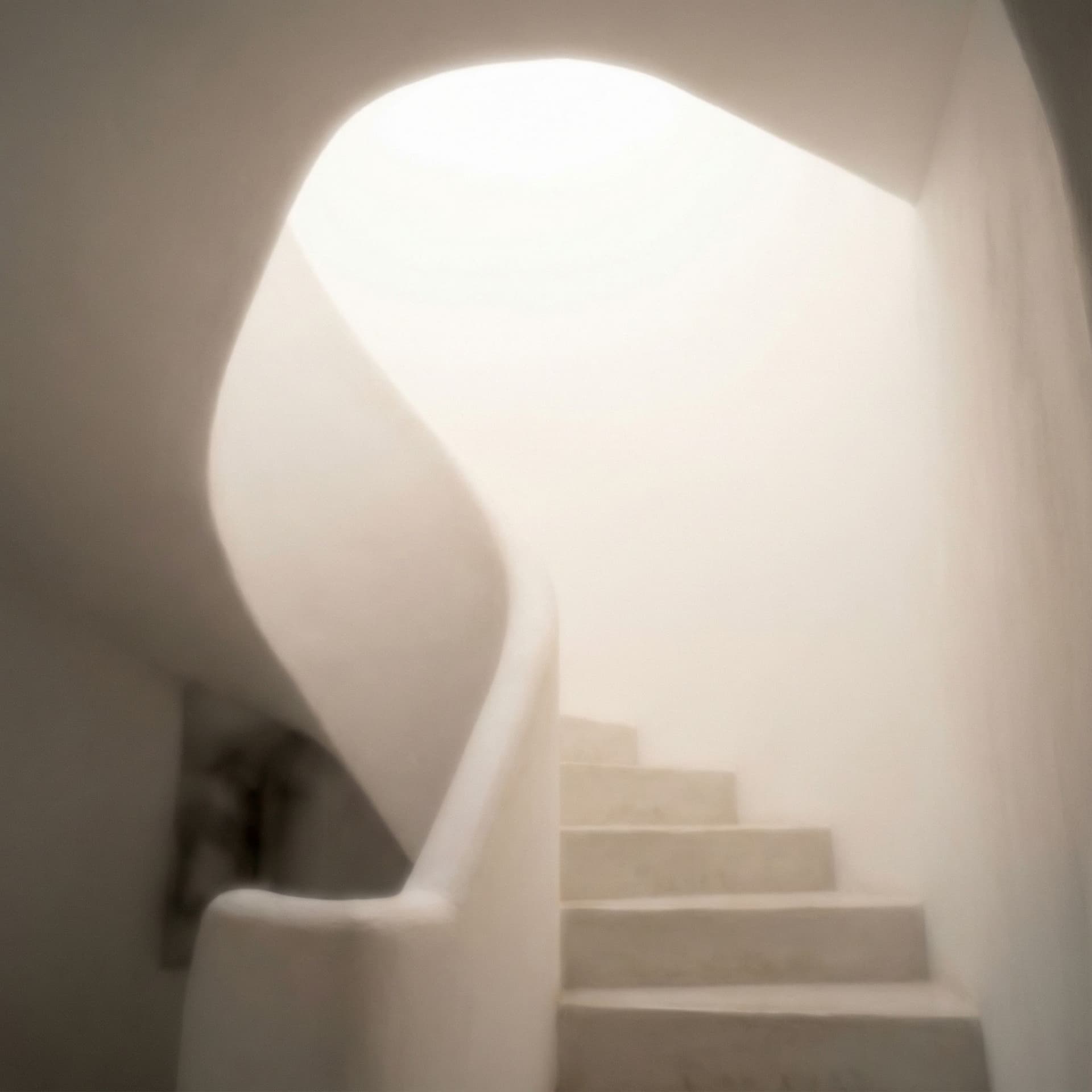 AI generated: A white stairwell rises into near-abstraction, flooded from above by a skylight that pours down a th...