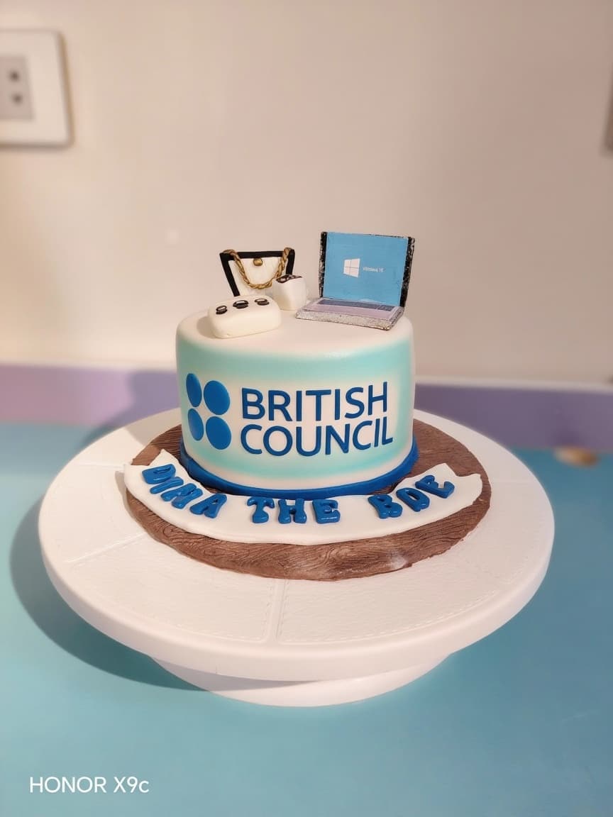 AI generated: High-quality food photo of a fondant cake with British Council logo, corrected colors, clean edges, ...
