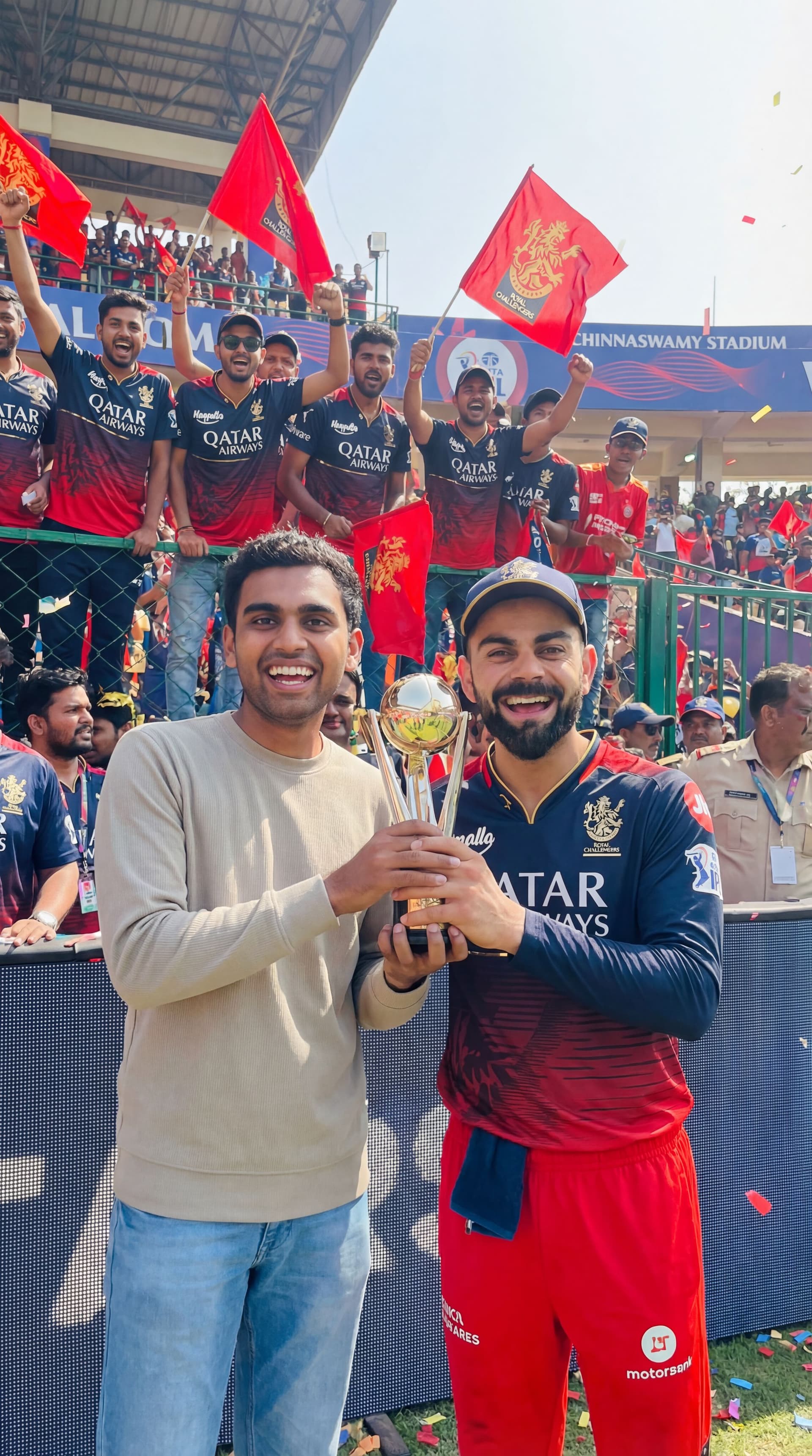 AI generated: Make this guy meet virat kohli with trophy and both should be happy and celebrating in chinnaswamy s...