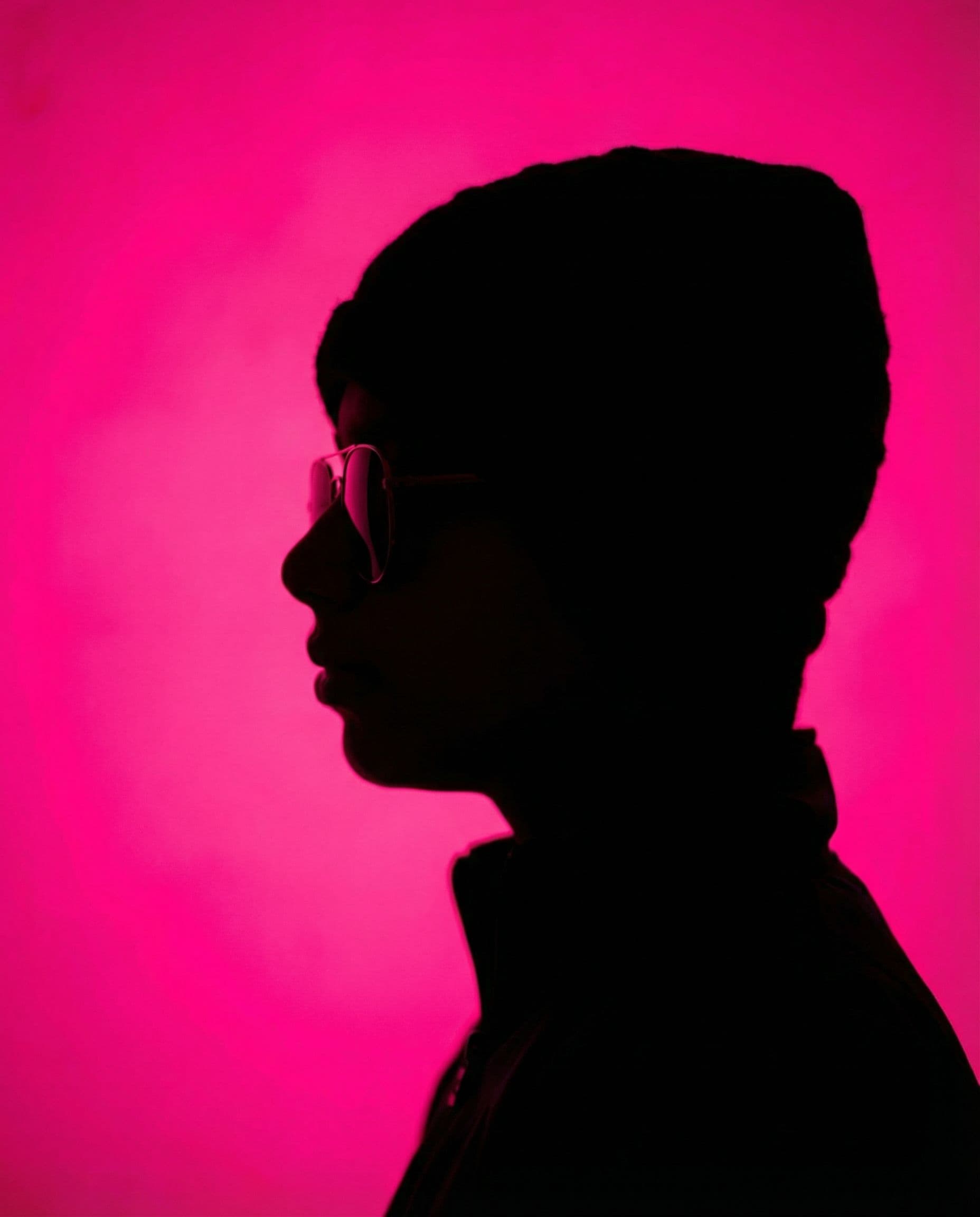 AI generated: photography, portrait of contrast, profile silhouette of a woman, vibrant hot pink backdrop, visuali...