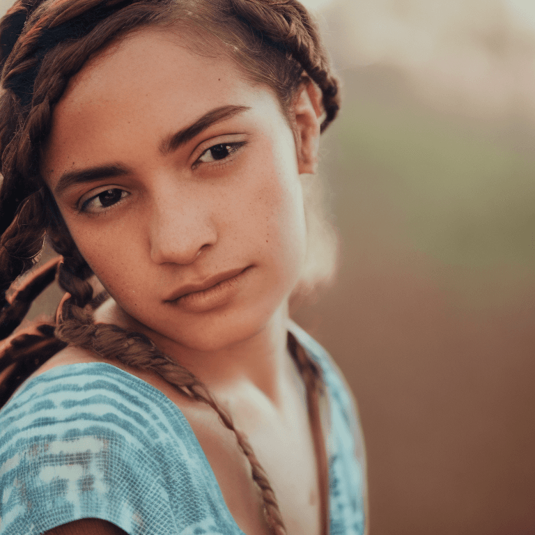 AI generated: A close-up portrait of a young woman with contemplative brown eyes and a side braid. Her olive skin ...