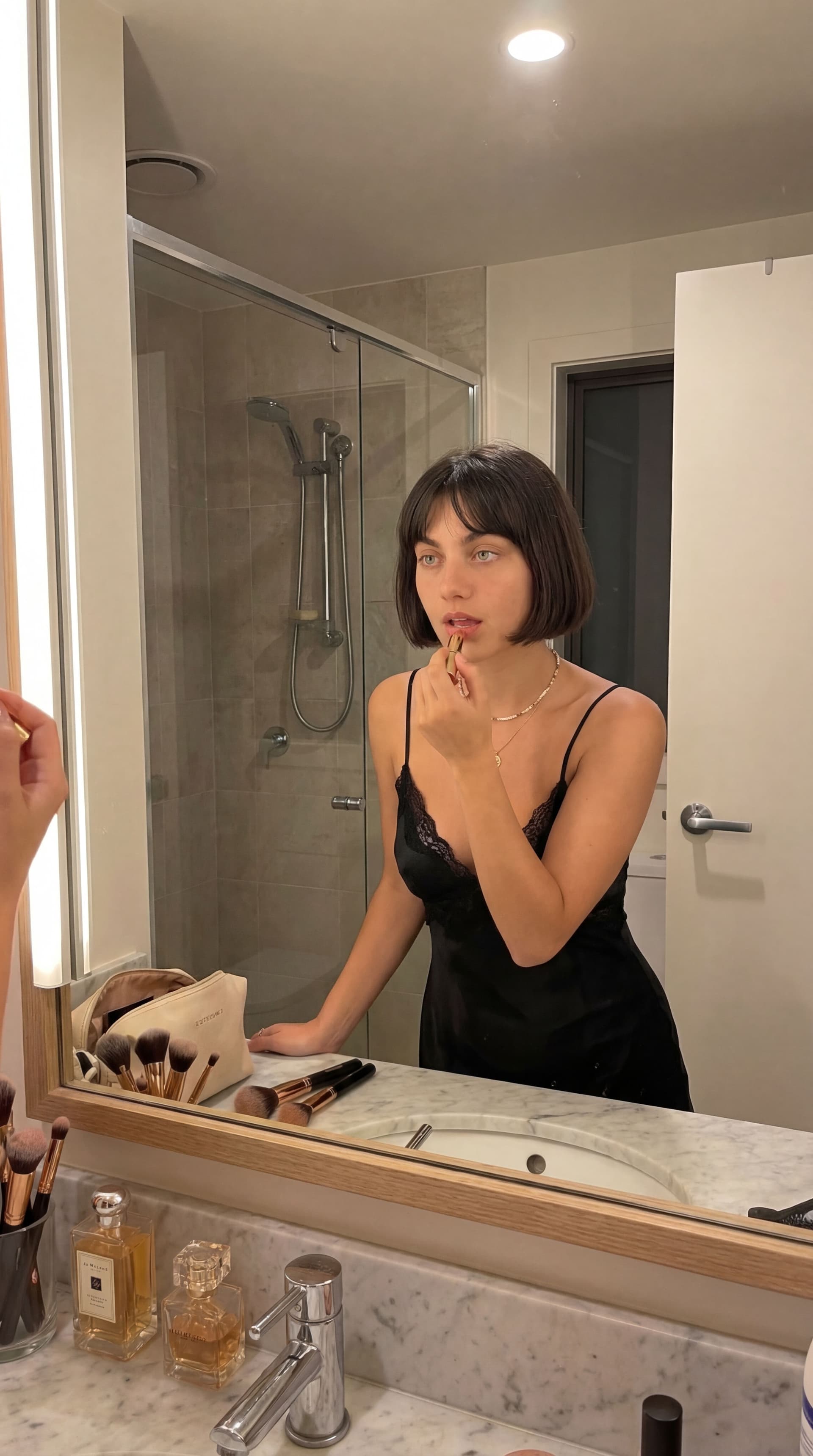 AI generated: this woman, but wearing a sexy dress in the bathroom, getting ready 