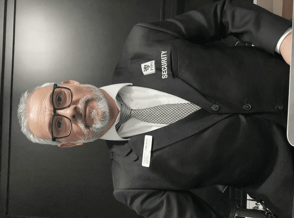 AI generated: make this guy look like he is wearing suit with the same company logo and a name tag that says NOMAN...