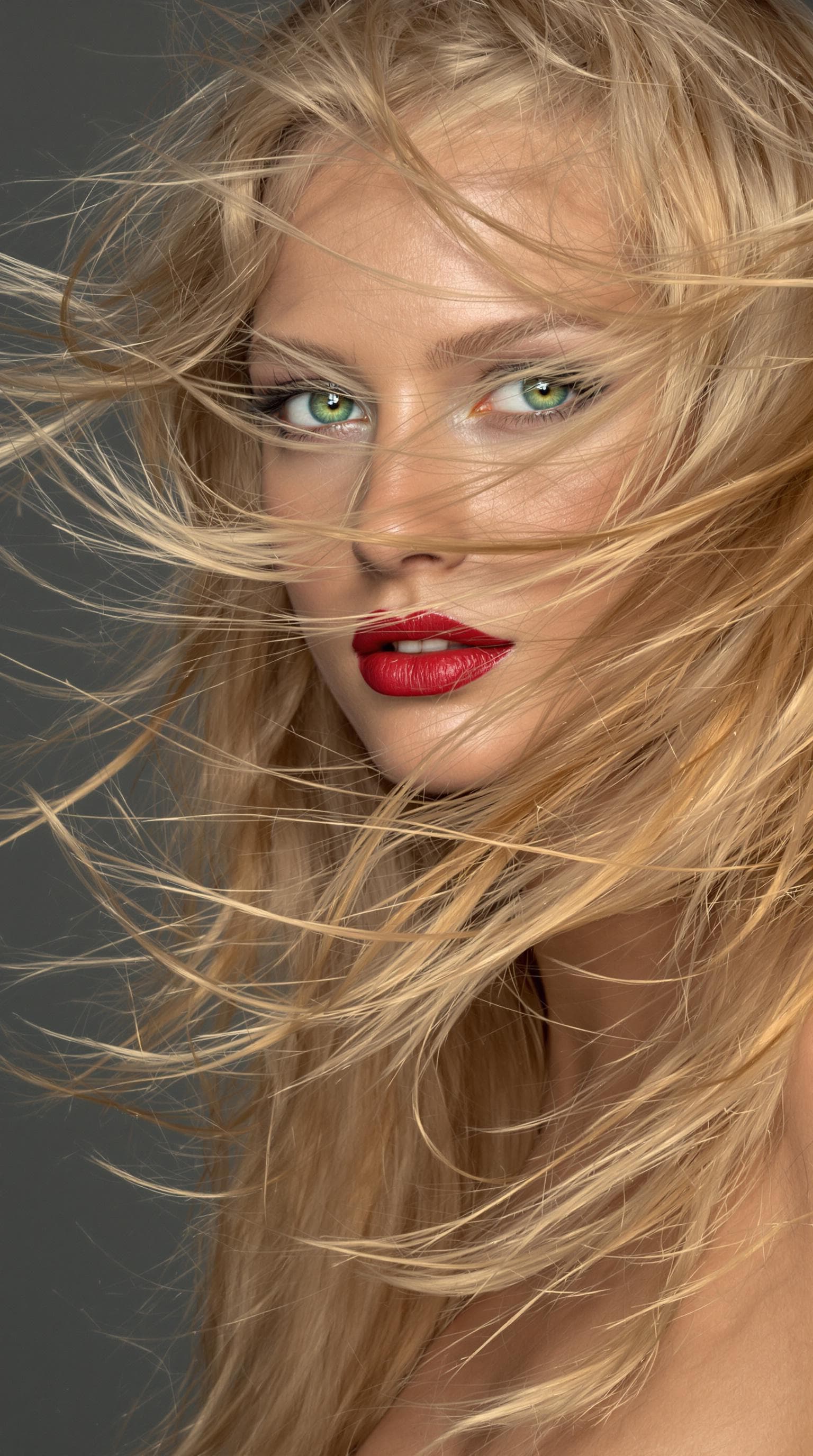 AI generated: "The image is a striking close-up portrait of a model with lustrous, tousled strawberry blonde hair ...