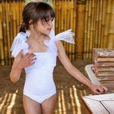 AI generated: A pretty, young brunette girl wearing a white swimsuit.