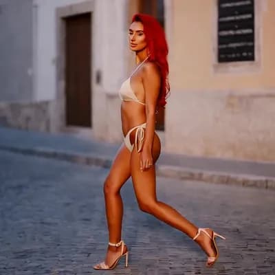 AI generated video: A woman wearing high heels and red hair wears a bikini and walks in the street 
