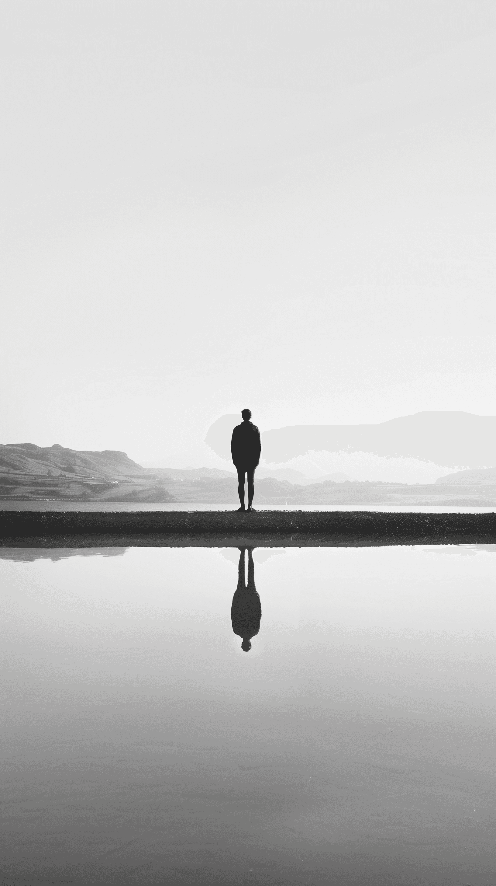 AI generated: lone figure standing at the edge of a still water body, image perfectly reflected below, almost symm...