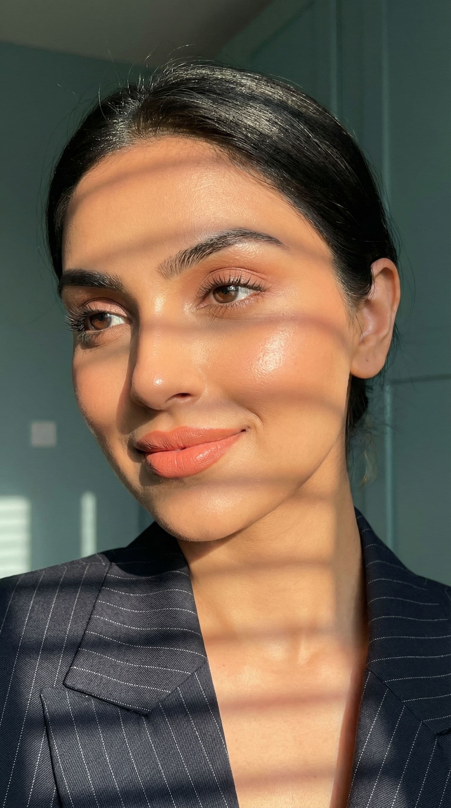 AI generated: Close-up portrait of a indian woman illuminated by soft, warm afternoon light streaming through wind...