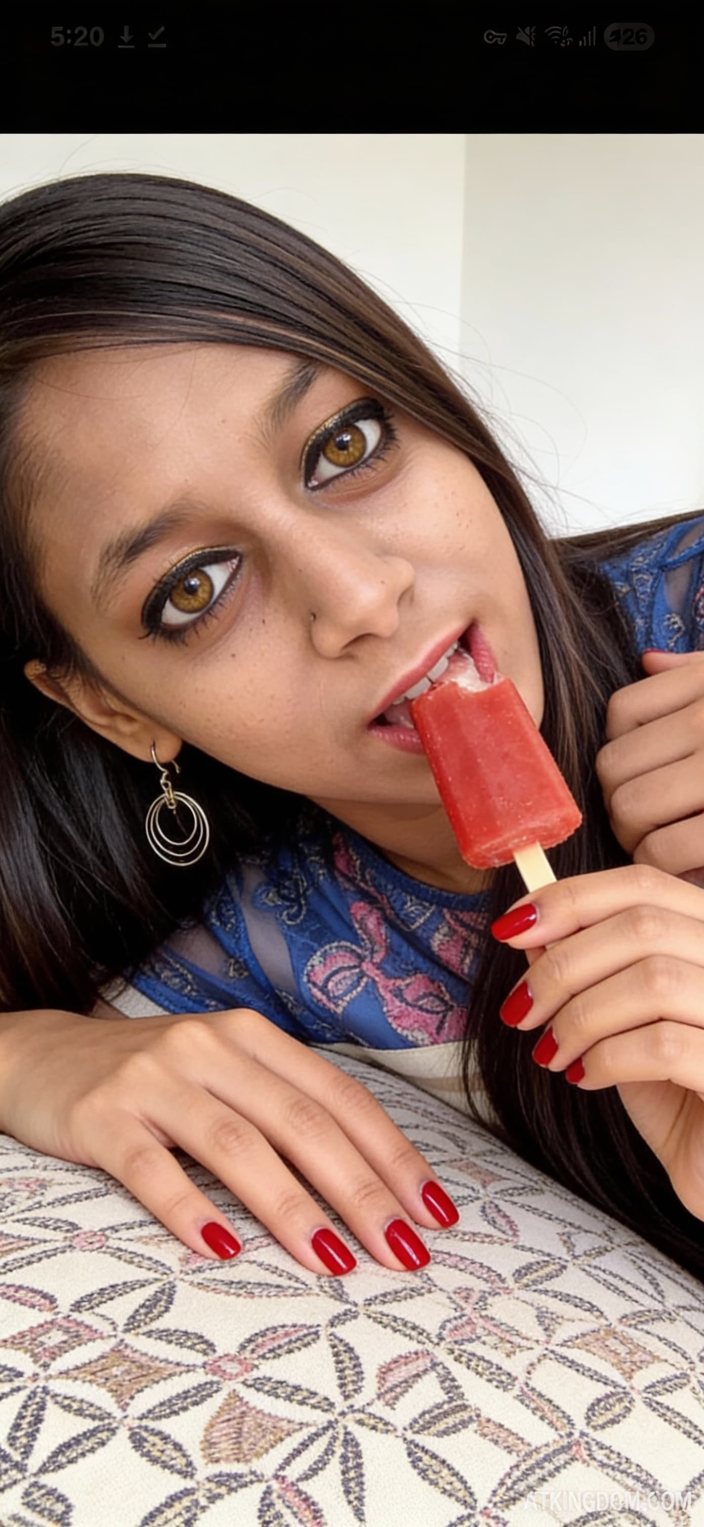 AI generated: The image shows a close-up photograph of a woman lying on her side on a patterned cushion or pillow....