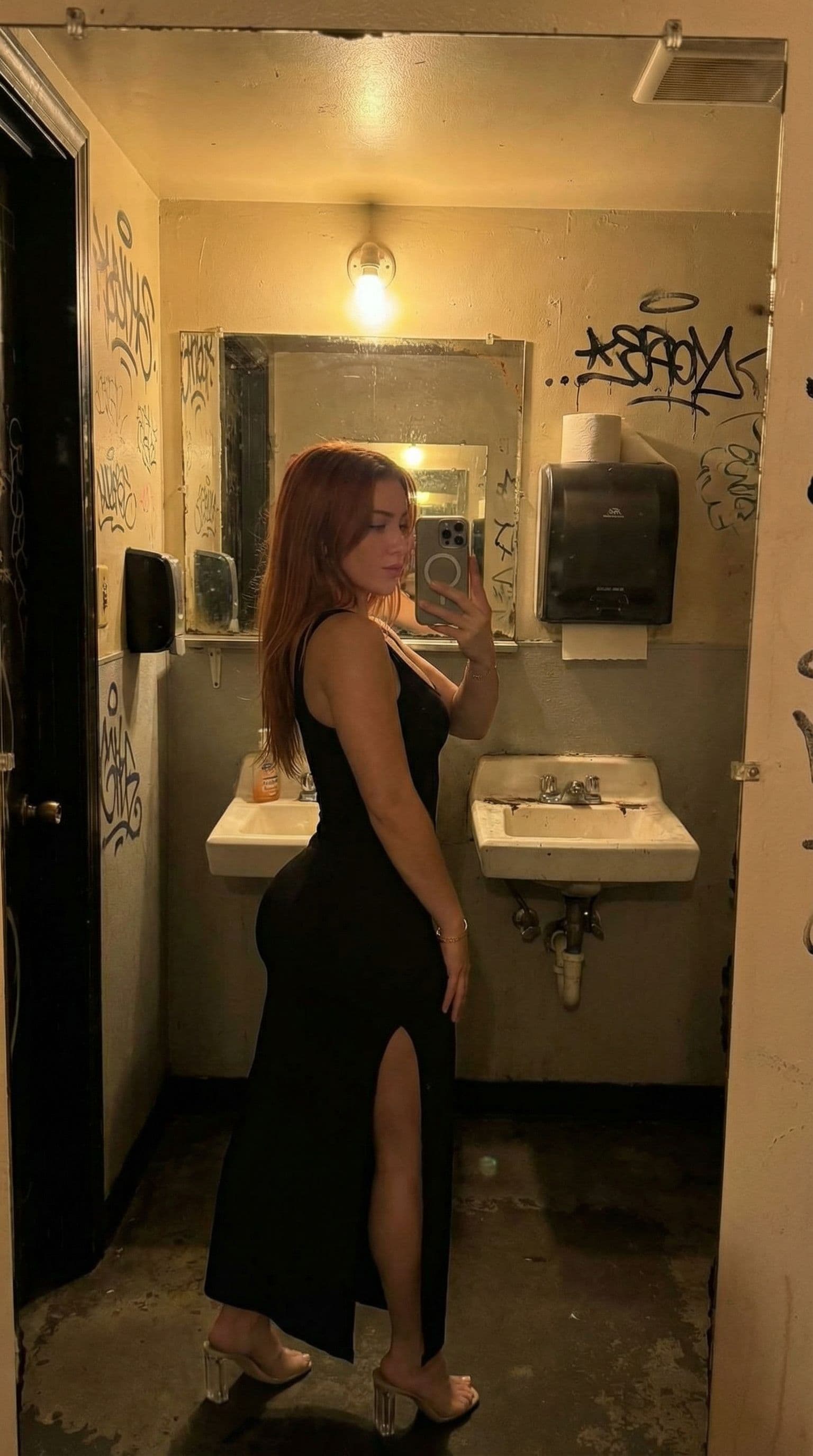 AI generated: give her a bubble butt, change scene to dive bar bathroom mirror