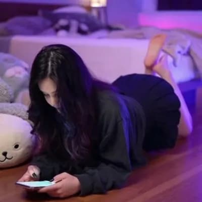 AI generated video: A dimly lit, cozy bedroom illuminated by soft purple-blue ambient lighting. A person lies comfortabl...
