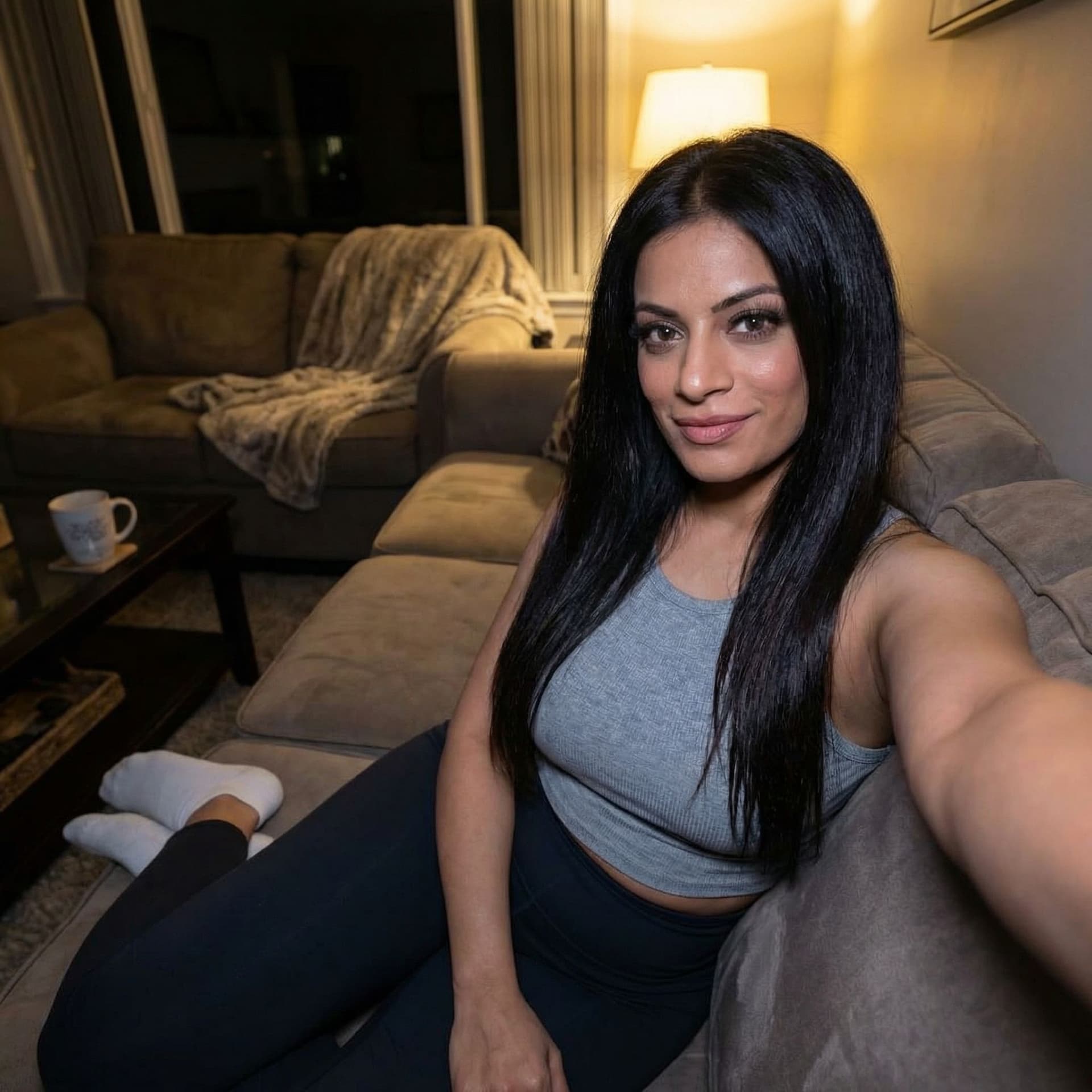 AI generated: Taking a selfie on a couch at night, wearing a cropped home tanktop and white socks, dont alter orig...