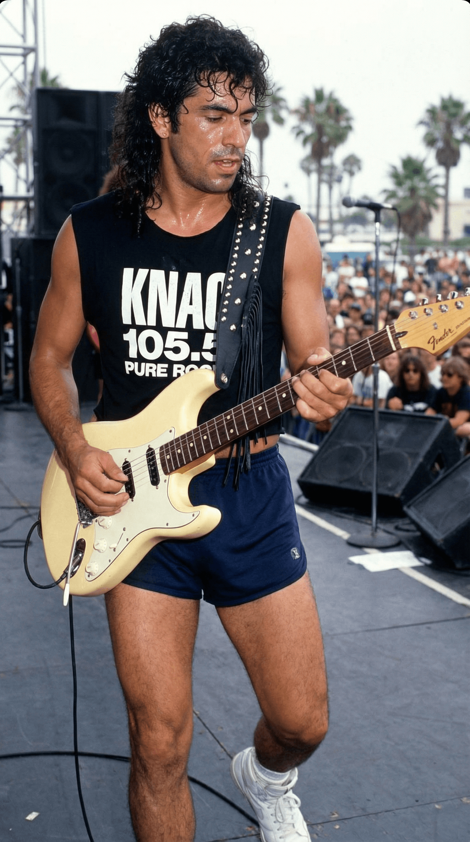 AI generated: Guitar player is on an outdoor stage in Long Beach, CA in the summer of 1989, wearing a black cut of...