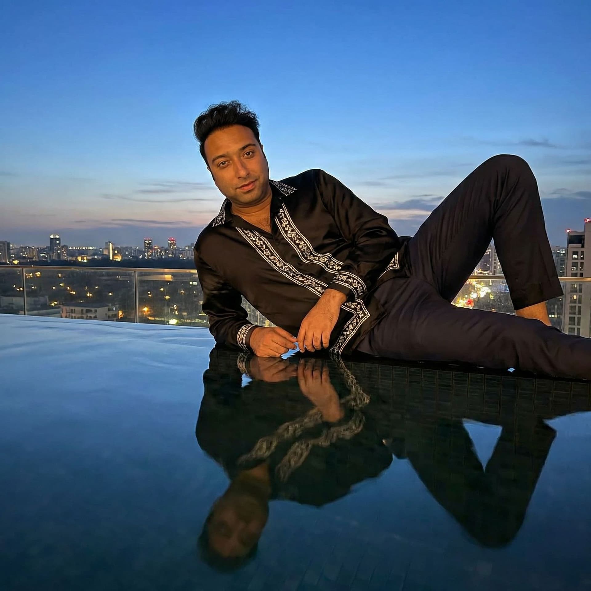 AI generated: Pop star lounging on luxury rooftop pool edge, city skyline at dusk. Effortlessly glamorous outfit, ...