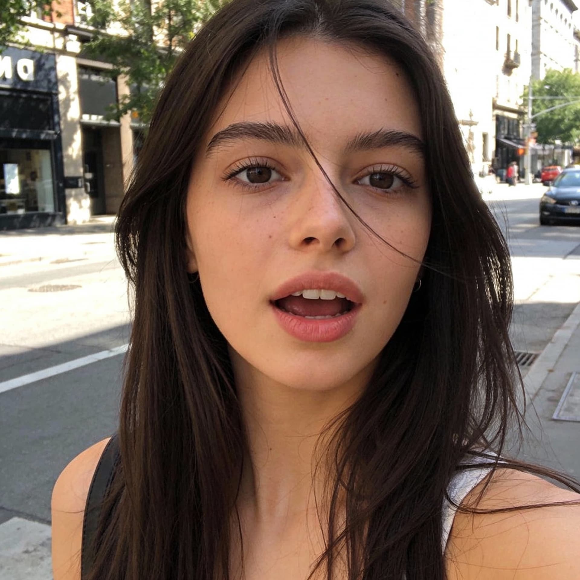 AI generated: A natural iPhone selfie in the middle of the street, soft daylight, realistic skin tones, slightly b...