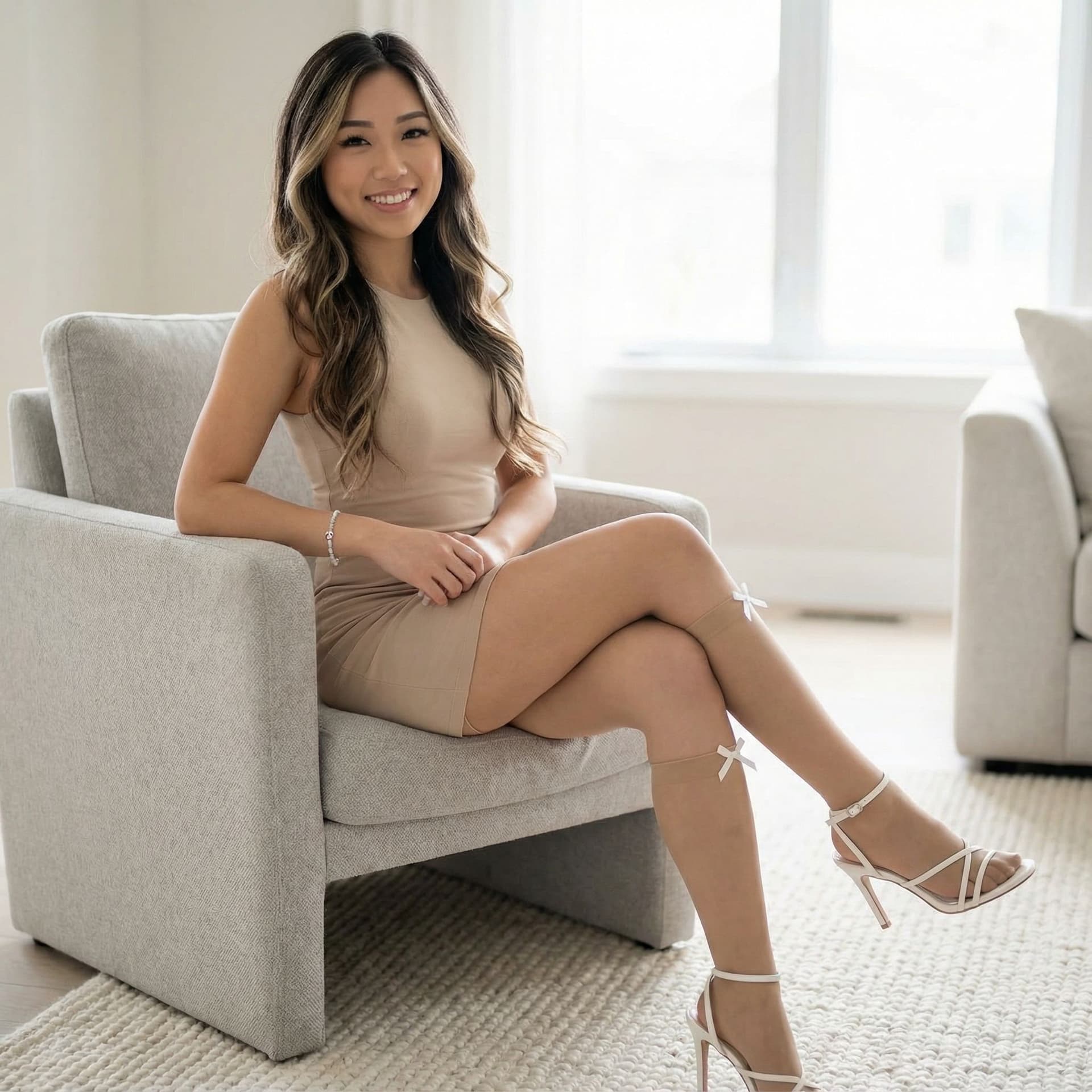 AI generated: young Asian woman seated in a modern, light gray armchair. She has long, wavy dark brown hair with s...