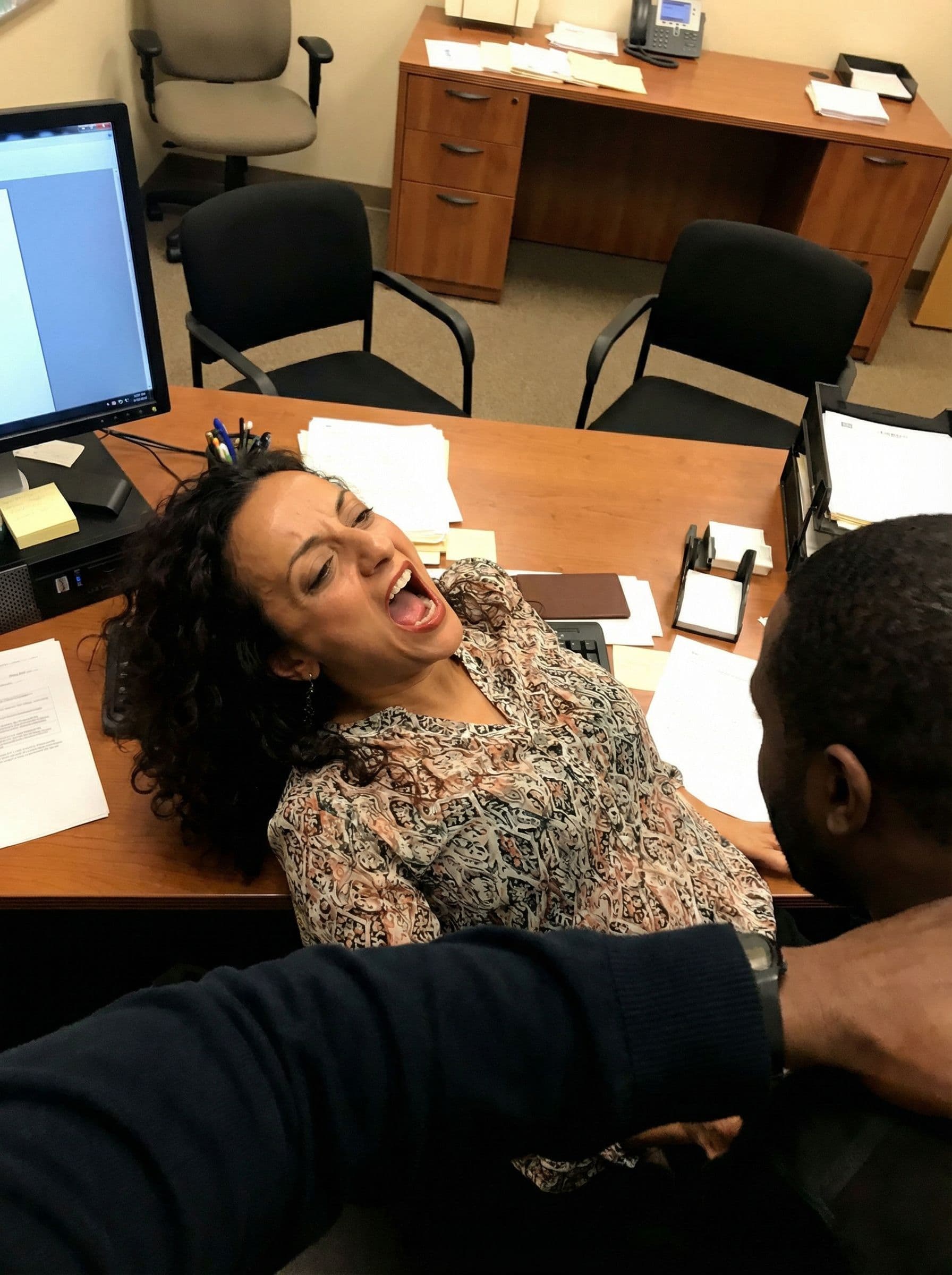 AI generated: <lora:POV_Anal_Missionary:0.8> Photo of a dark curly haired woman laying on her back on an office de...